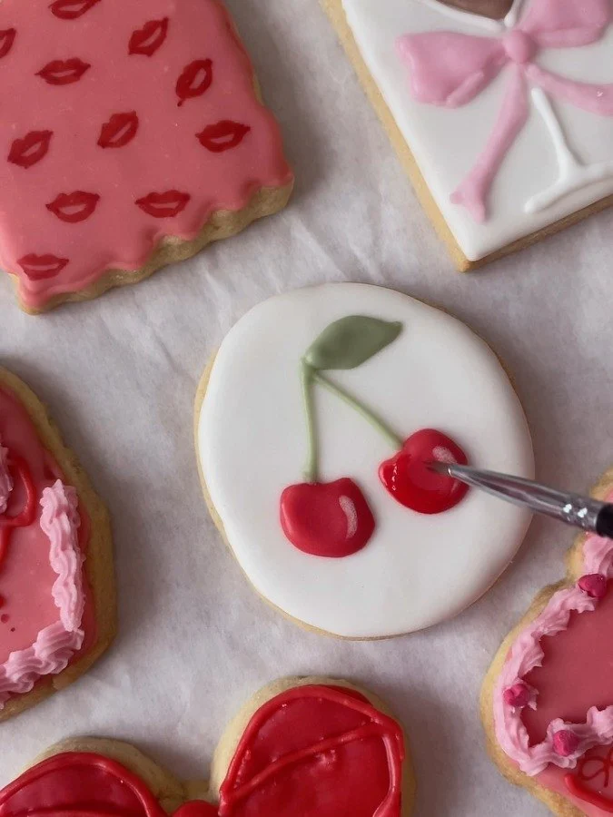 Cherry and bow biscuits being painted
