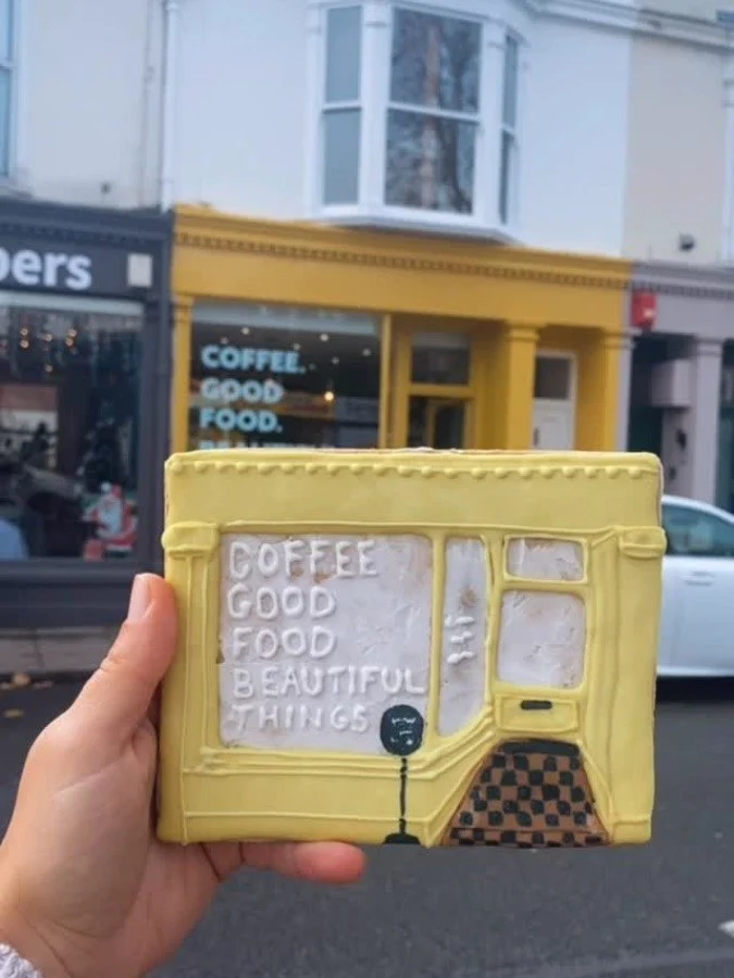 A Southsea coffee shop front recreated in biscuit, held up outside the real shop